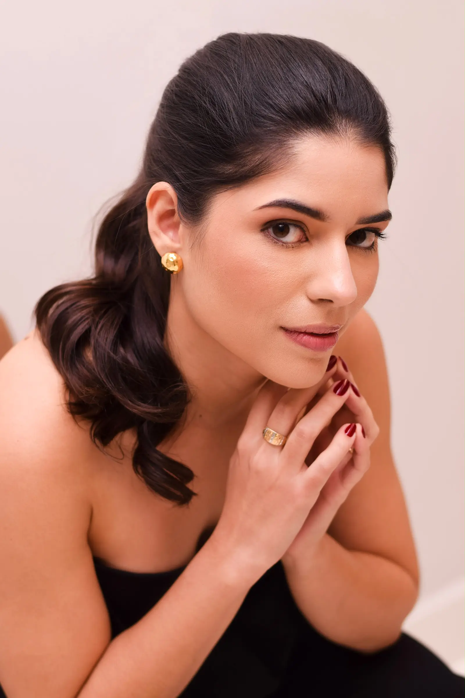 Retrato da arquiteta Júlia Mendes, apoiando o queixo nas mãos